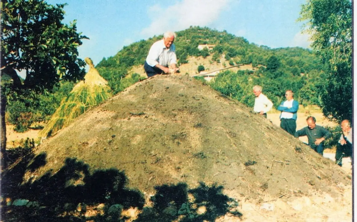 Carboners vigilant el procés de cocció de la sitja